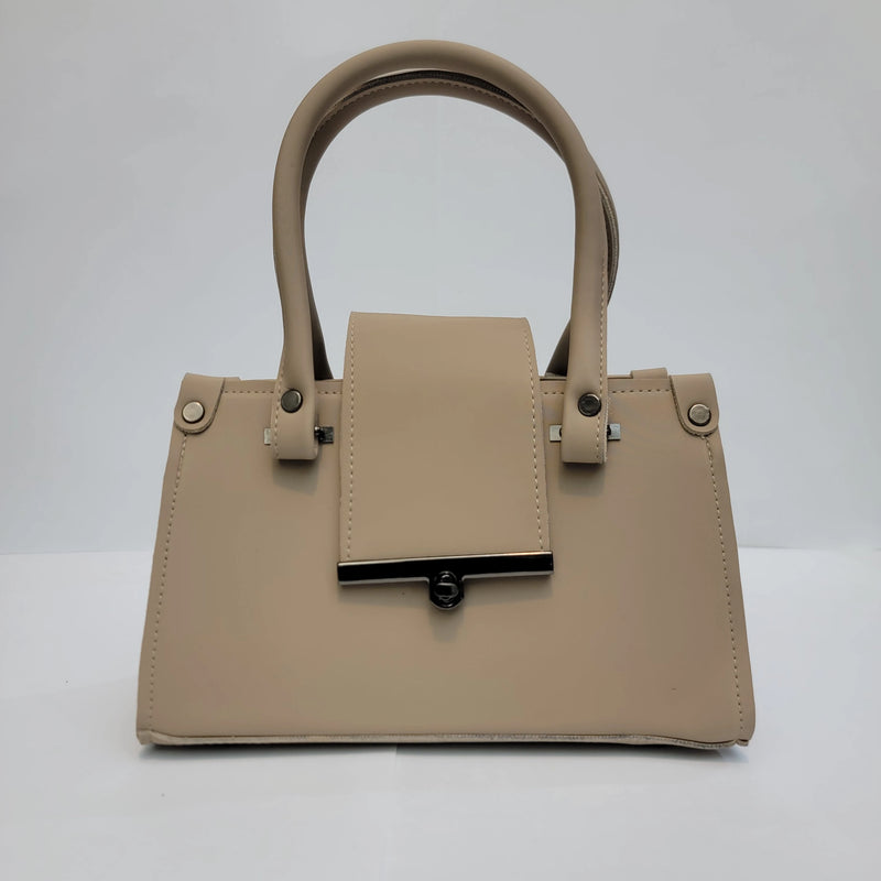 A structured beige faux-leather handbag with dual top handles, a front flap detail, and silver-tone hardware, photographed against a neutral light gray background.