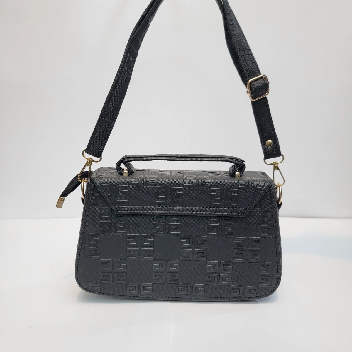 Black embossed leather handbag with a top handle, adjustable shoulder strap, and gold-tone hardware, photographed against a plain white background.