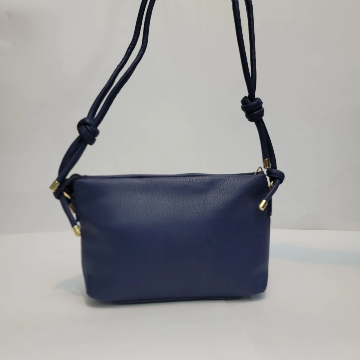 Cross B. navy blue envelope-style crossbody bag, close-up of front flap