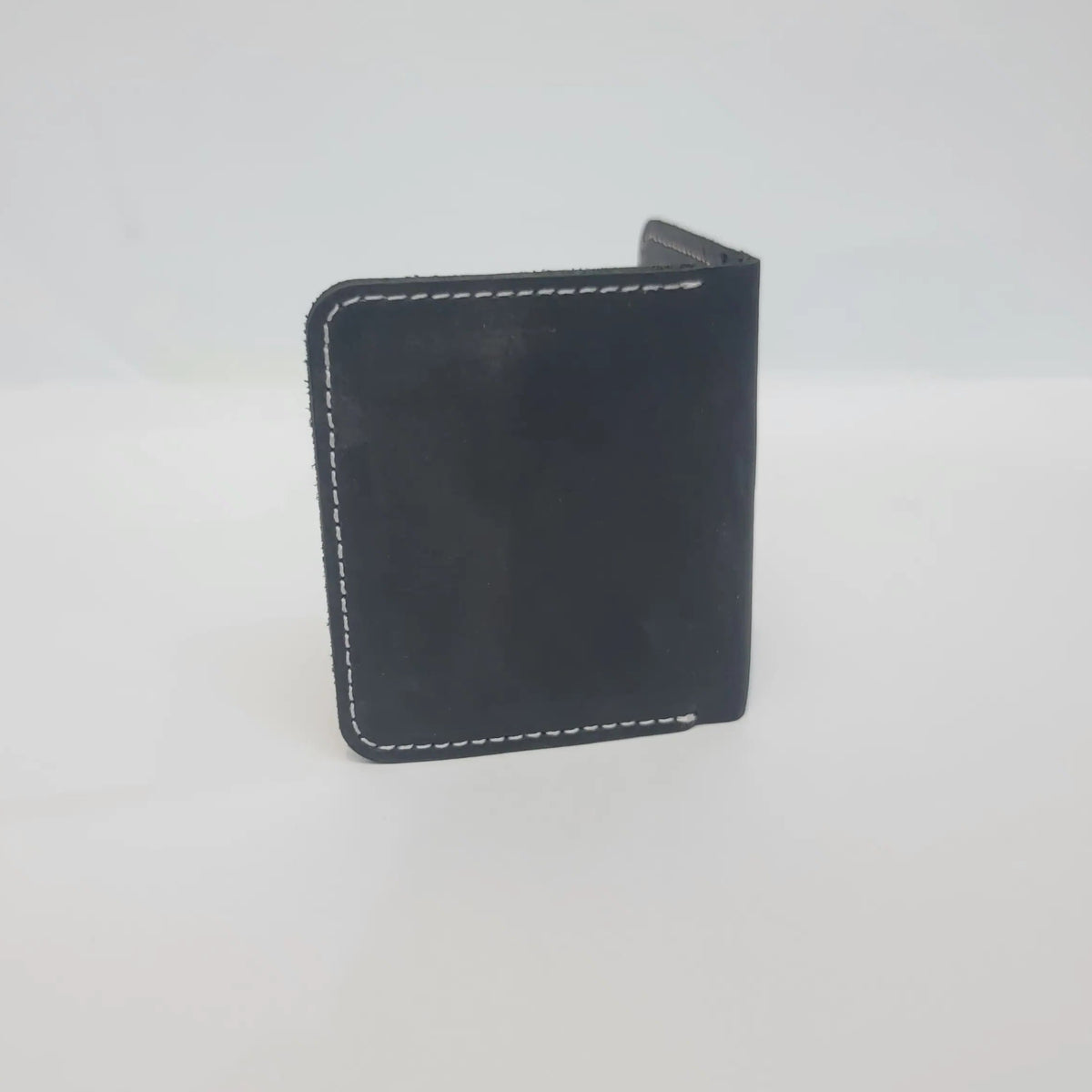 A small black leather card holder or wallet with white contrast stitching, shown against a plain white background.