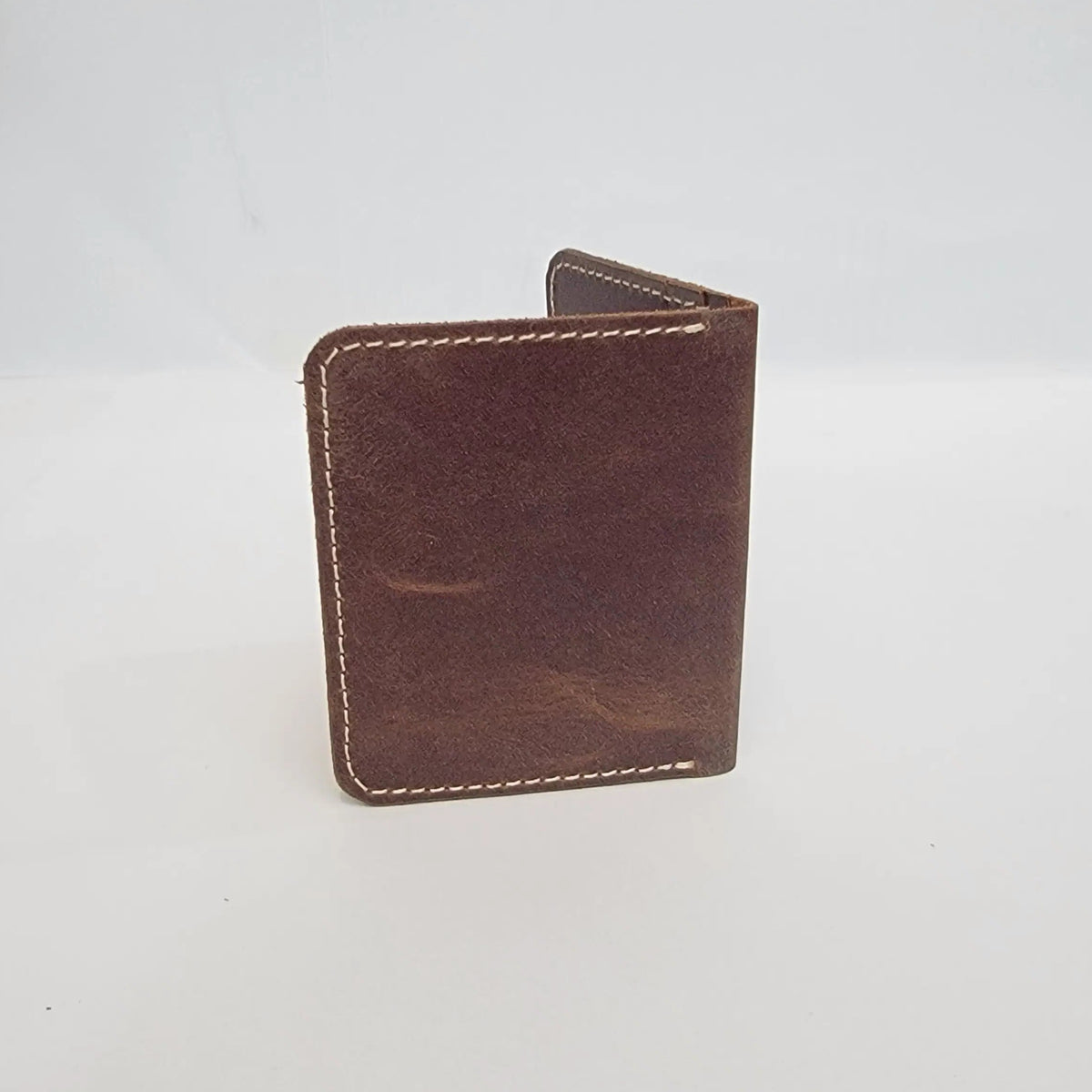 A small brown leather card holder or wallet with visible contrast stitching, photographed against a plain white background.
