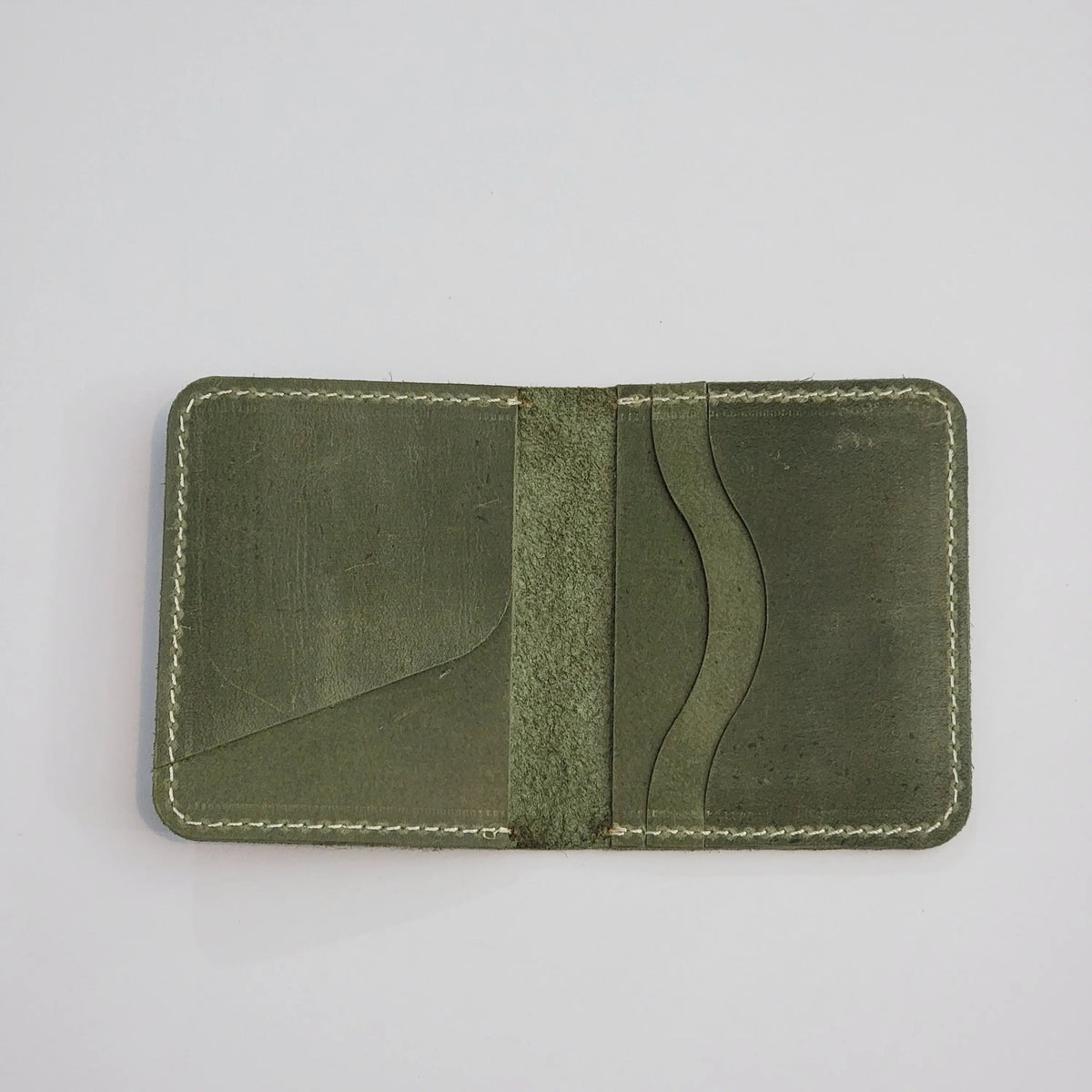 An olive green leather card holder wallet with white contrast stitching, shown open against a plain white background.