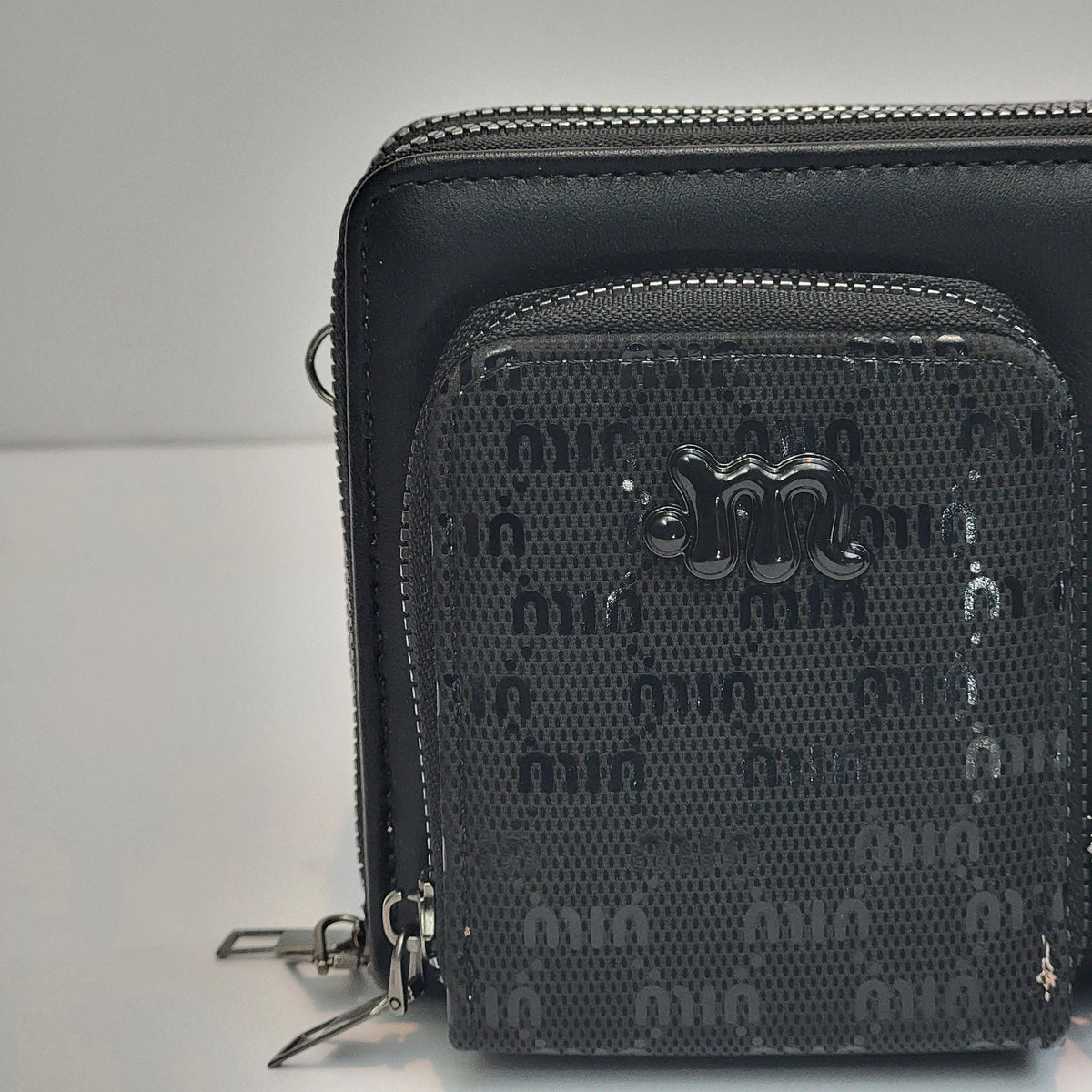 Cross B. black crossbody bag, close-up of front pockets and strap