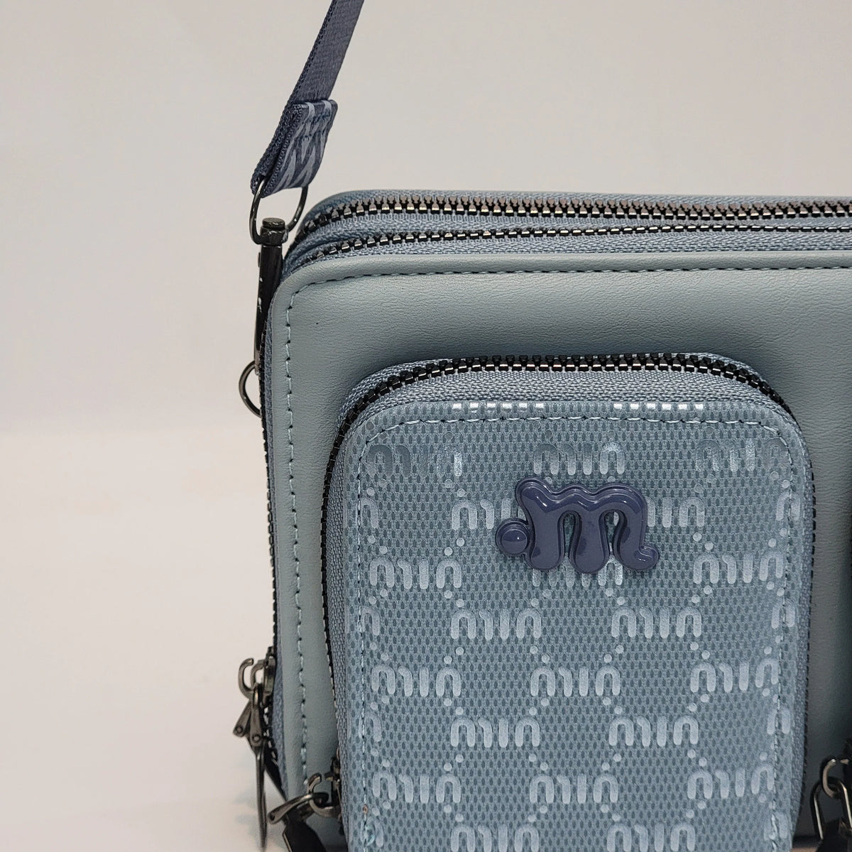 Cross B. blue crossbody bag, close-up of front pockets and strap