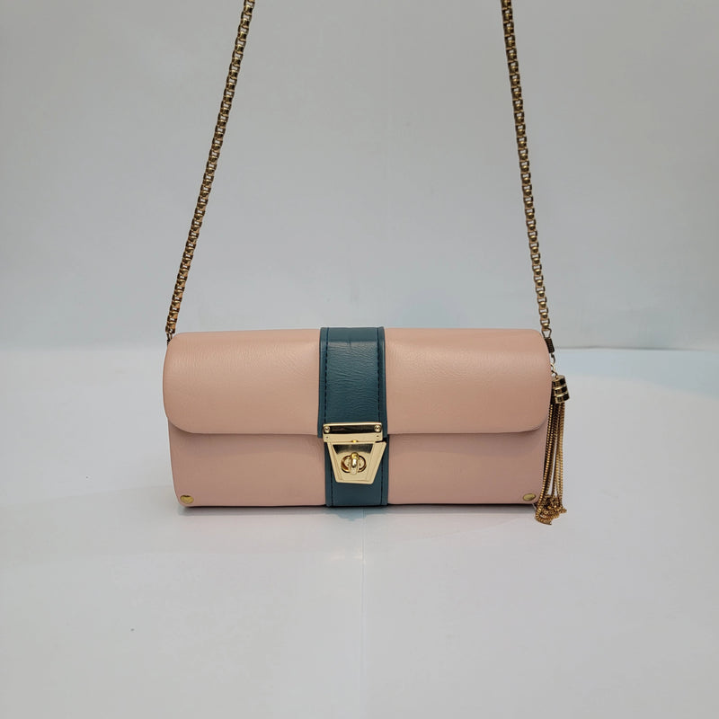 A structured shoulder bag in blush pink and teal leather with gold-tone hardware, featuring a chain strap and a tassel detail.