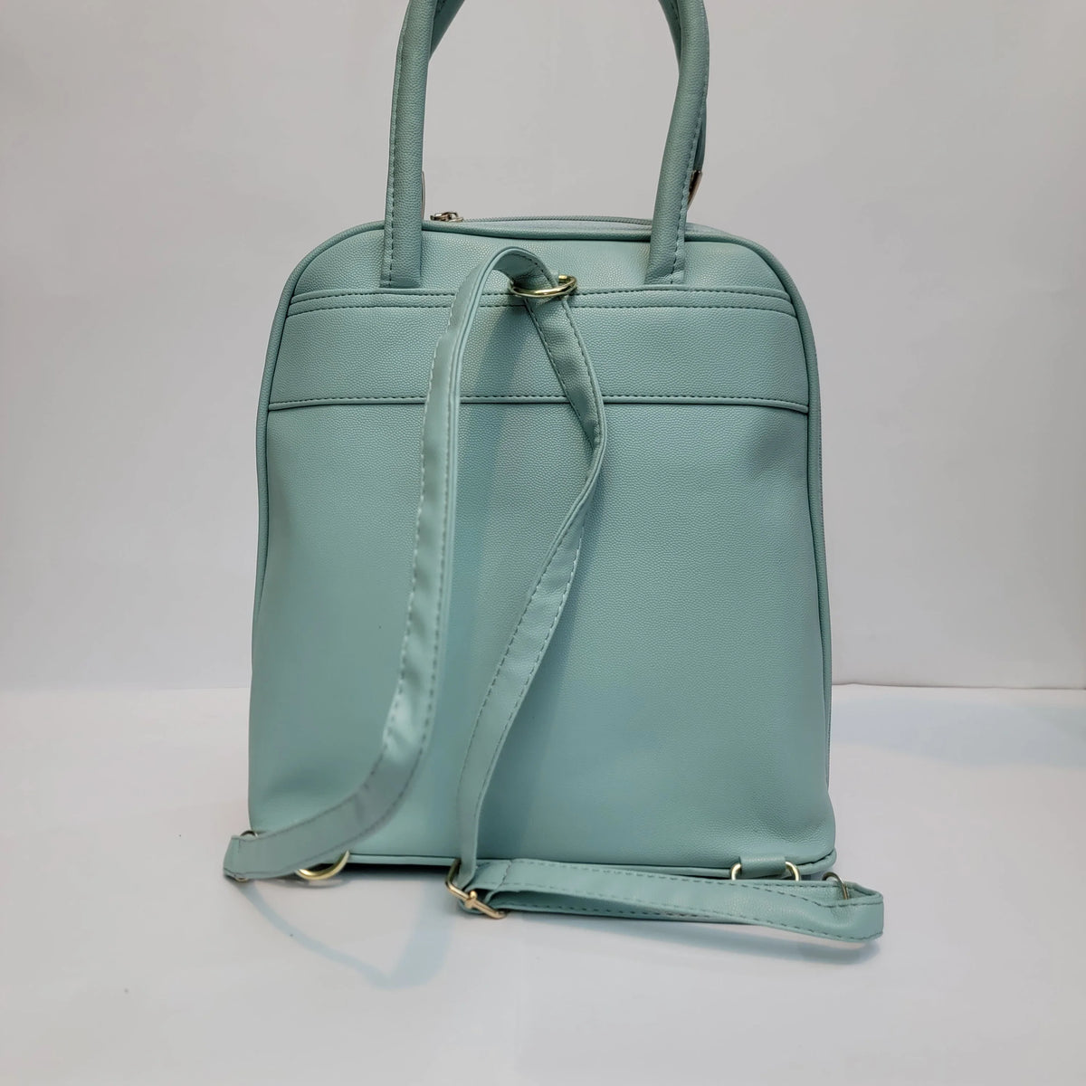Cross B. sage green faux-leather backpack, side view showing adjustable straps