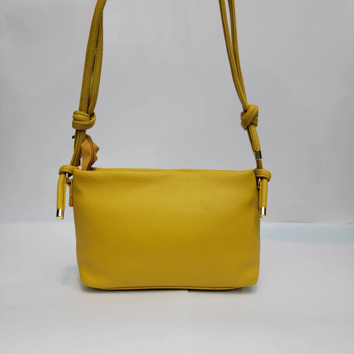 Cross B. yellow envelope-style crossbody bag, close-up of front flap